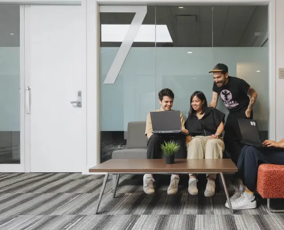 Students sitting outside of project rooms in a school setting